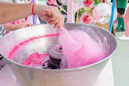 Woman,making,pink,cotton,candy,at,a,street,fair,food