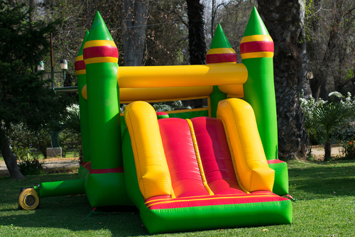 Inflatable,castle,game,green,with,yellow,in,the,garden