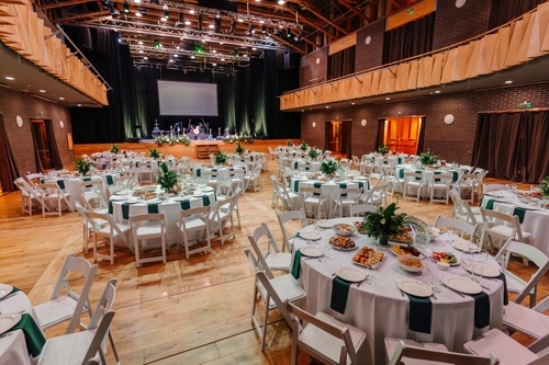 Large,event,hall,with,elegantly,set,round,tables,,floral,centerpieces,